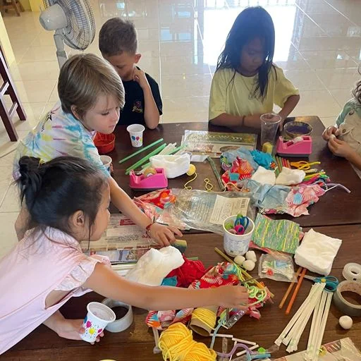 Children creating with craft materials at Shining Stars School Kamala