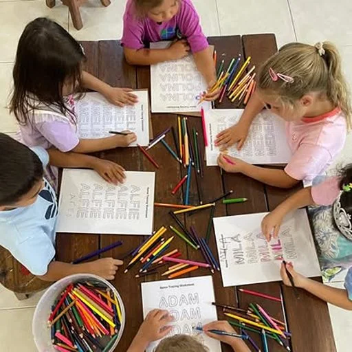 Child practising name tracing and early literacy at Shining Stars School Kamala