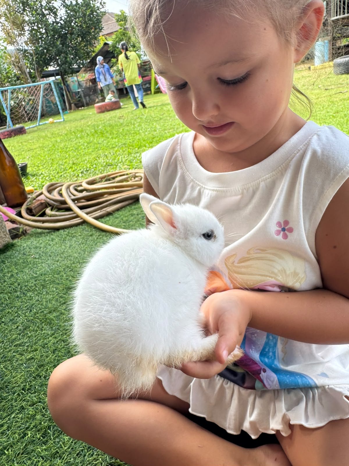 Child holding a rabbit during an animal learning activity at Shining Stars School Kamala
